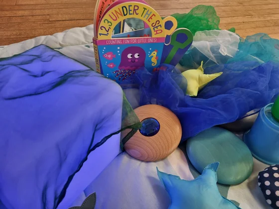An underwater storybook surrounded by blue scarves and soft stars